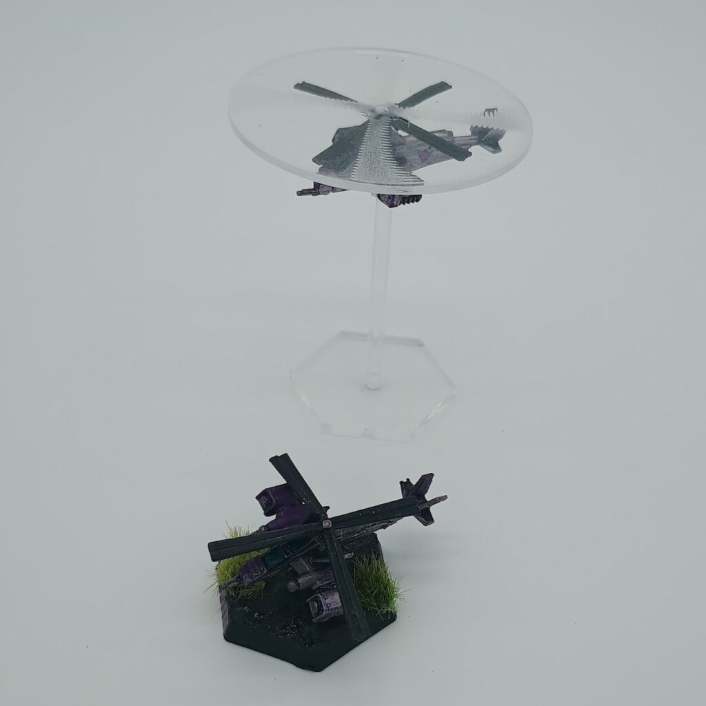 two miniatures of Balac VTOLs, silver on the left and purple on the right