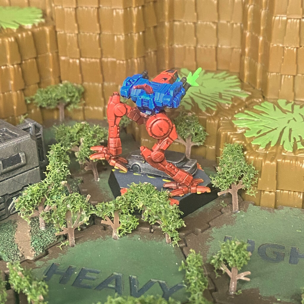 a Locust miniature kitbashed with weapon effects, painted with red legs and blue body