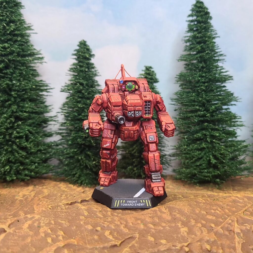 a Cyclops miniature painted red with a green cockpit