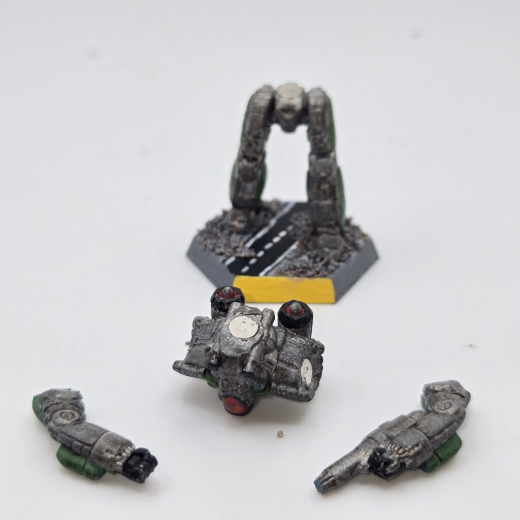 Chameleon miniature painted metallic grey with green accents. The torso and arms have been magnetized and disassembled