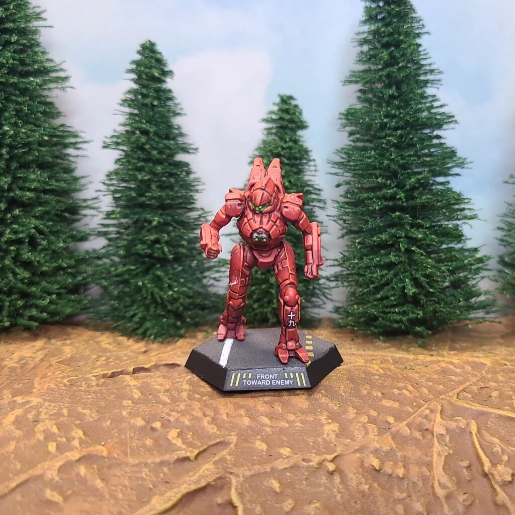 a Spider miniature painted red with green cockpit accents