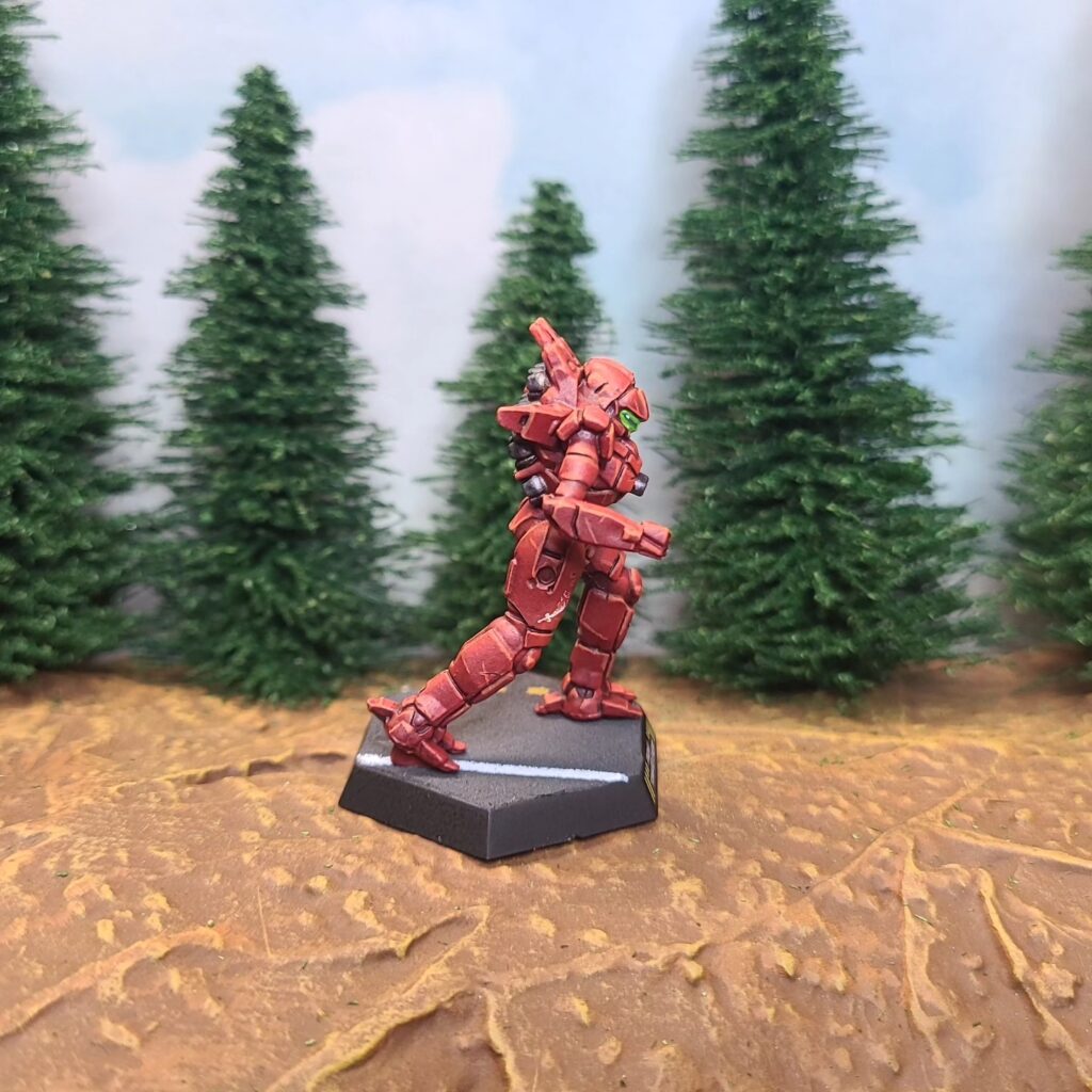 a Spider miniature painted red with green cockpit accents