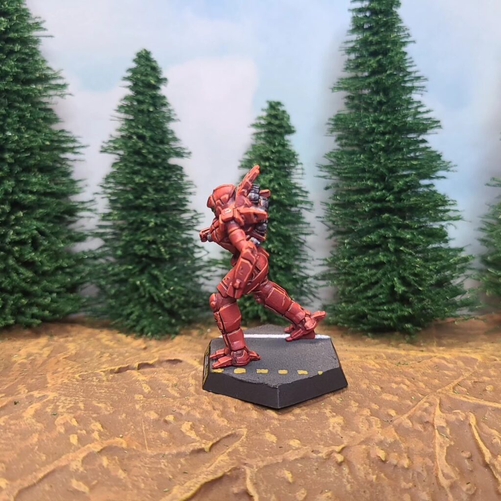a Spider miniature painted red with green cockpit accents