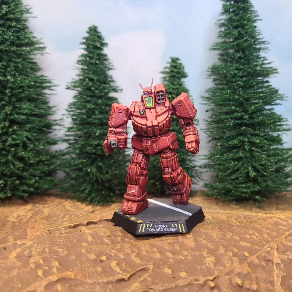 a Wolverine miniature painted red with green cockpit accents