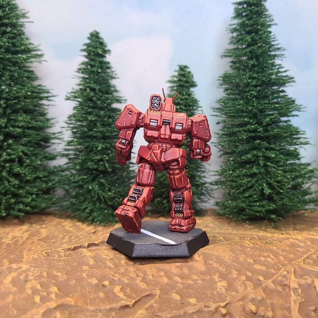 a Wolverine miniature painted red with green cockpit accents